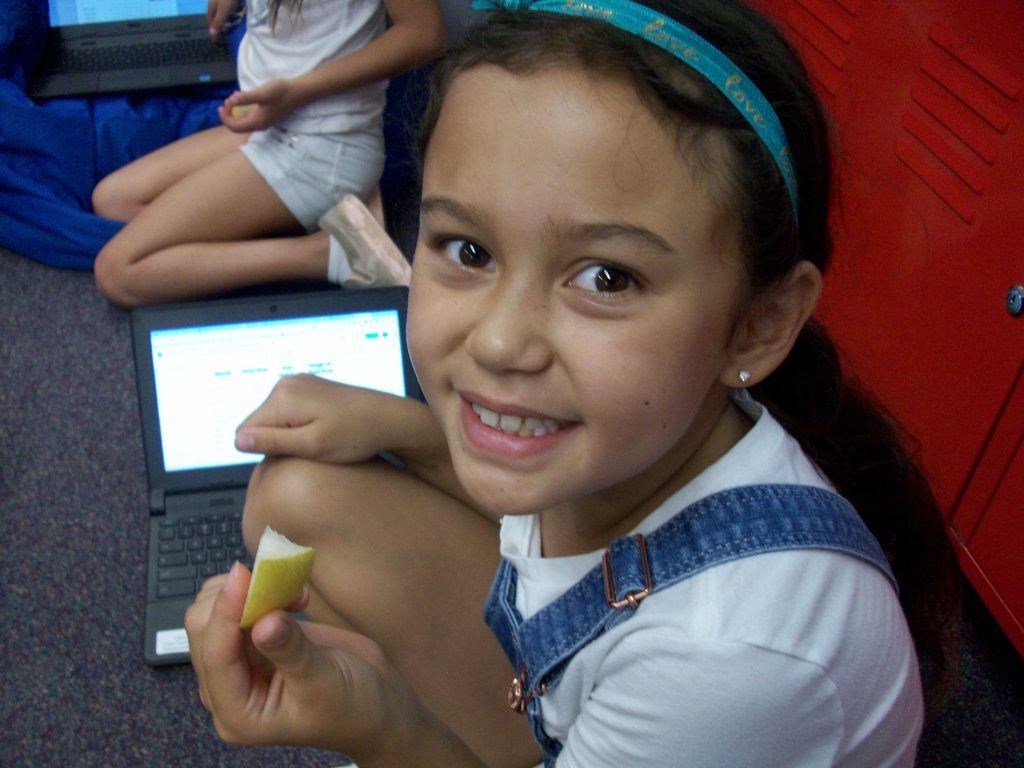 A student eats a yellow pear