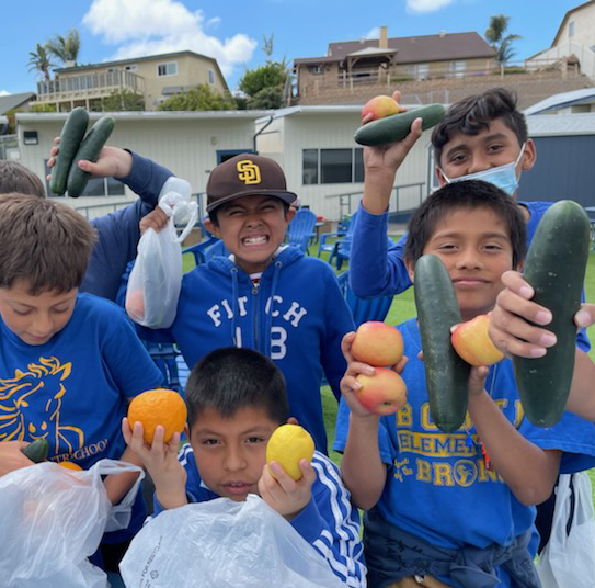 students at Bobier Elementary holding the fruits and vegetables they got at the farmers market